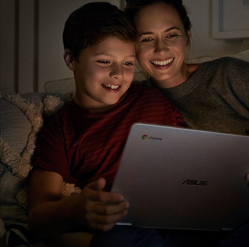 Une femme et son enfant, souriants, regardent l'écran d'un ordinateur portable.
